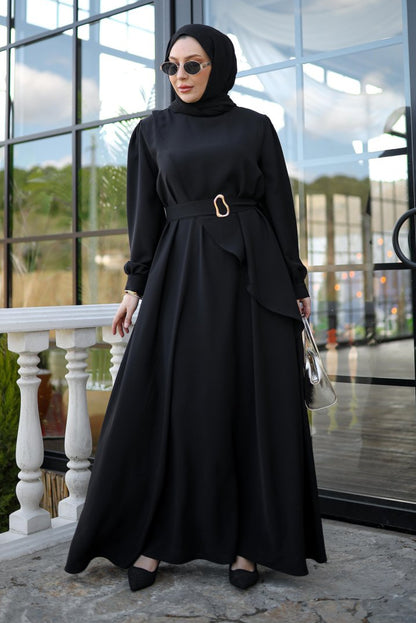 Woman in a black outfit standing in front of a glass door.